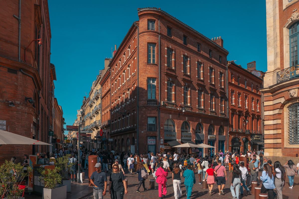 Rue animée du centre historique de Toulouse, façades de brique rouge